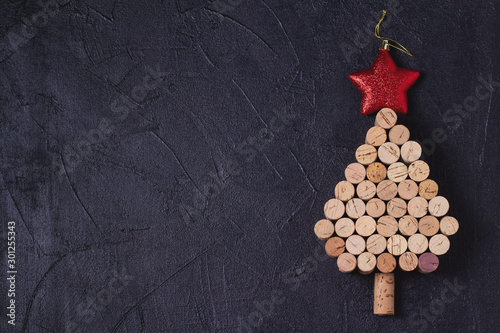 Christmas tree made of  wine corks on black background. Layout, flat lay, template. New Year winter holidays background. Copy space