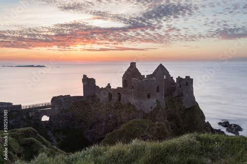 Dunluce Castle in Northern Ireland during a stunning sunset.