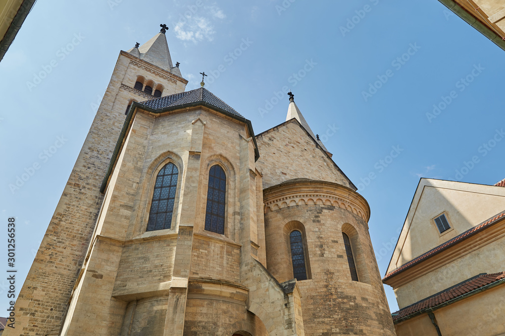 Church from beige bricks with large windows against the blue sky on a bright sunny day in Prague, Czech Republic.