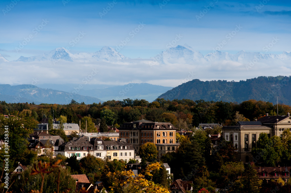 Beautiful picture of Bern in autumn, with the alps covered in snow in background.