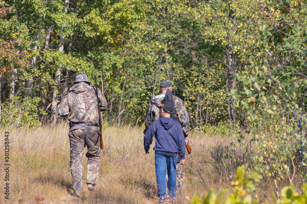 Hunters with weapons and children go hunting