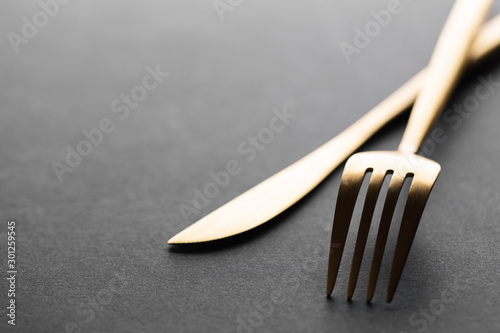 Gold cutlery set on black background photo