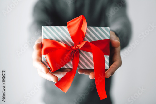 Man holding gift with red ribbon photo