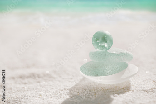 blue sea glass with white sand beach