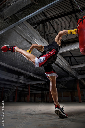 Athletic Men Hitting Punching, Boxing Bag. Boxing, MMA Men Workout with Boxing Bag