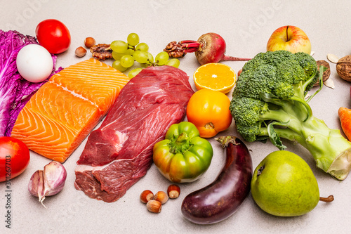 Trending paleo/pegan diet. Healthy balanced food concept. Set of fresh products, raw meat, salmon, vegetables and fruits