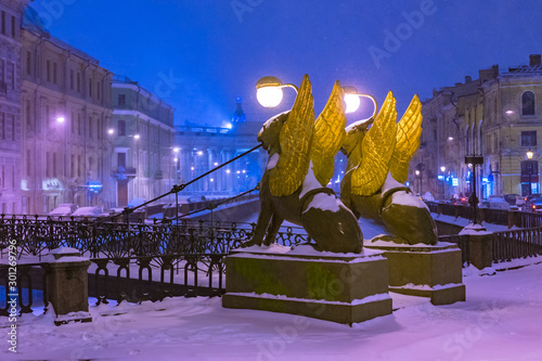 Saint Petersburg. Russia. Rivers Of St. Petersburg. Bridges Of St. Petersburg. Bank bridge. Griboedov channell. Griffins with Golden wings. Lights in a snowy city. Travel to Russia. photo