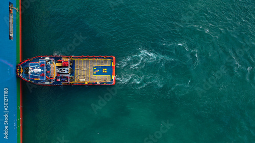 Obraz na plátně Aerial top down view of tug pilot boat assist vessel pushing large tanker to pos