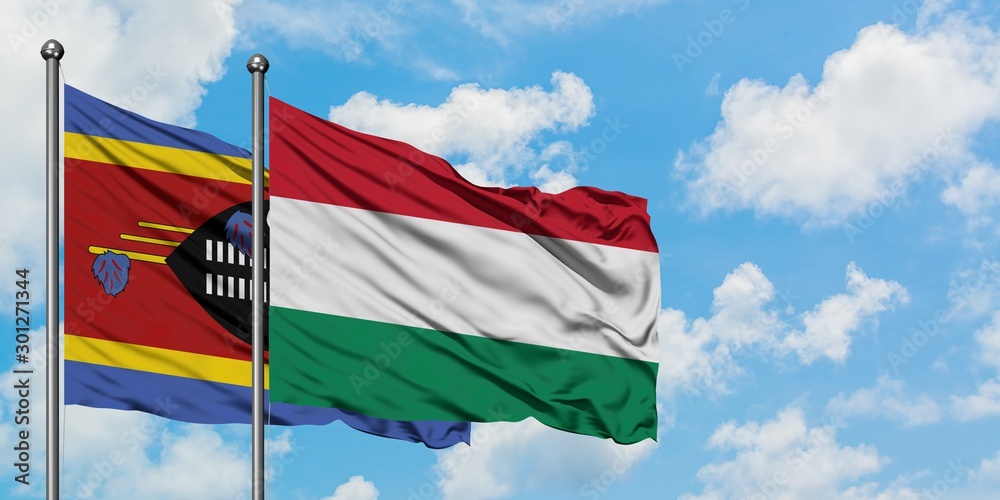 Swaziland and Hungary flag waving in the wind against white cloudy blue sky together. Diplomacy concept, international relations.