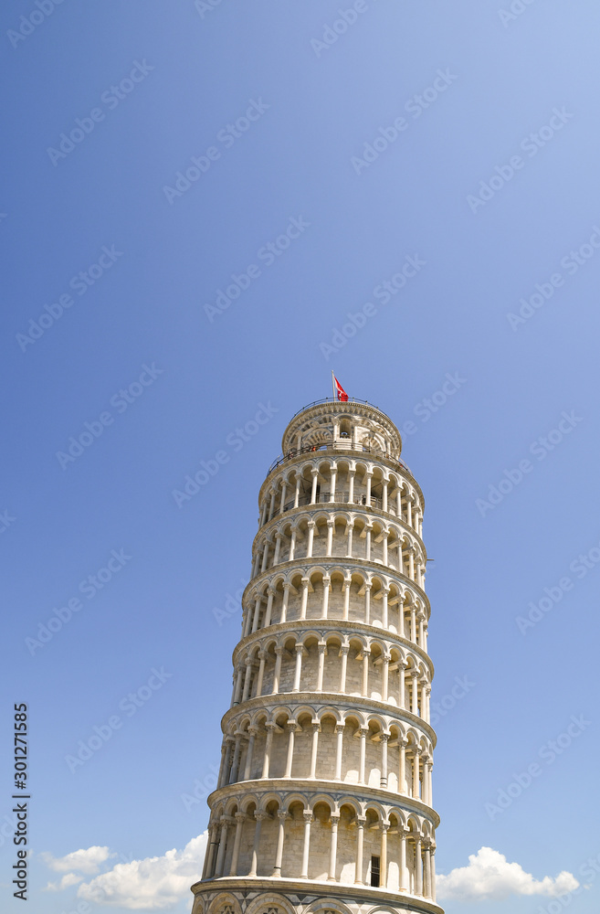 Vertical view of the famous Leaning Tower of Pisa in Piazza dei Miracoli square in the city center of the popular tourist destination against clear blue sky, Tuscany, Italy 