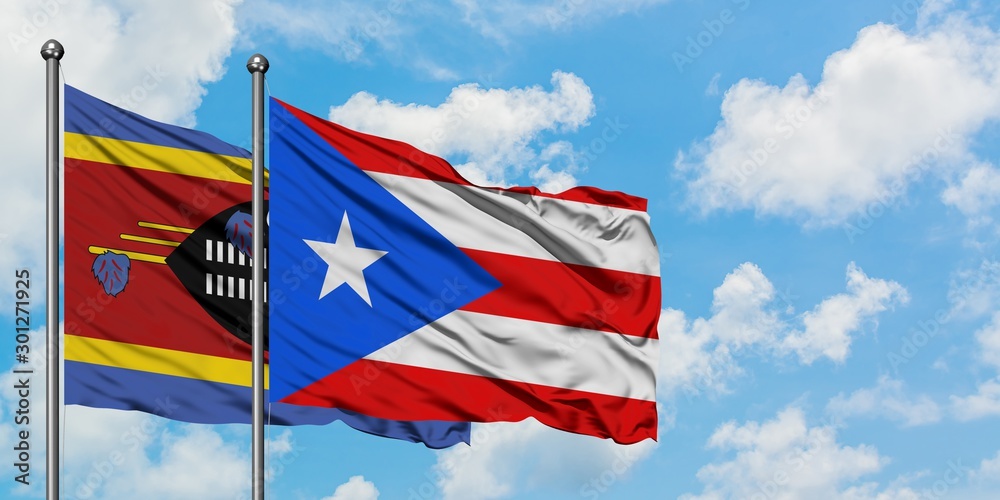 Swaziland and Puerto Rico flag waving in the wind against white cloudy blue sky together. Diplomacy concept, international relations.