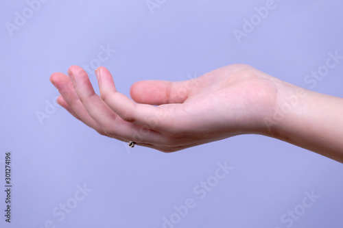 Open a woman's hand, palm up isolated on blue background © lunarts_studio