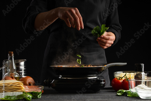 Vászonkép Cooking by a chef Italian lasagna, frying a dressing in a frying pan