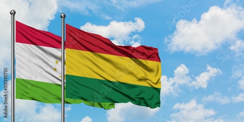 Tajikistan and Bolivia flag waving in the wind against white cloudy blue sky together. Diplomacy concept  international relations.