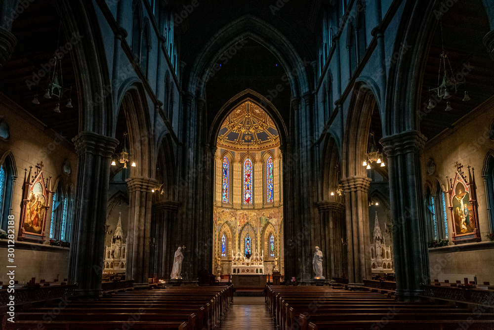KILKENNY, IRELAND, DECEMBER 23, 2018: Interior of St. Mary's Cathedral, partly illuminated with a mixture of darkness o light, with biblical statues and nobody around.