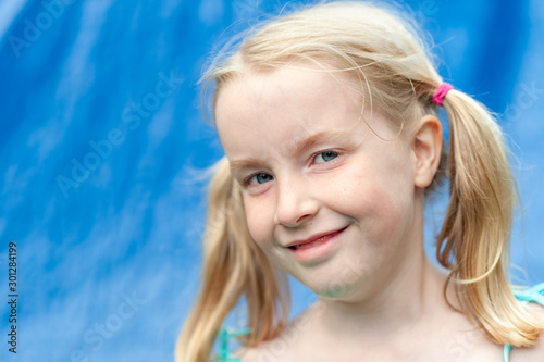 Tableau sur toile Pretty young blonde girl with pigtails smiling at the camera