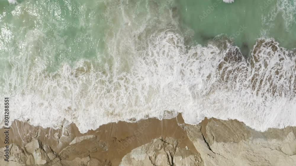 Aerial Top Shot view Drone Footage of waves bouncing on rocks at the beach. Beautiful blue turquoise transparent sea atlantic ocean. South France. Beautiful landscape in 4K. Side tracking to left.