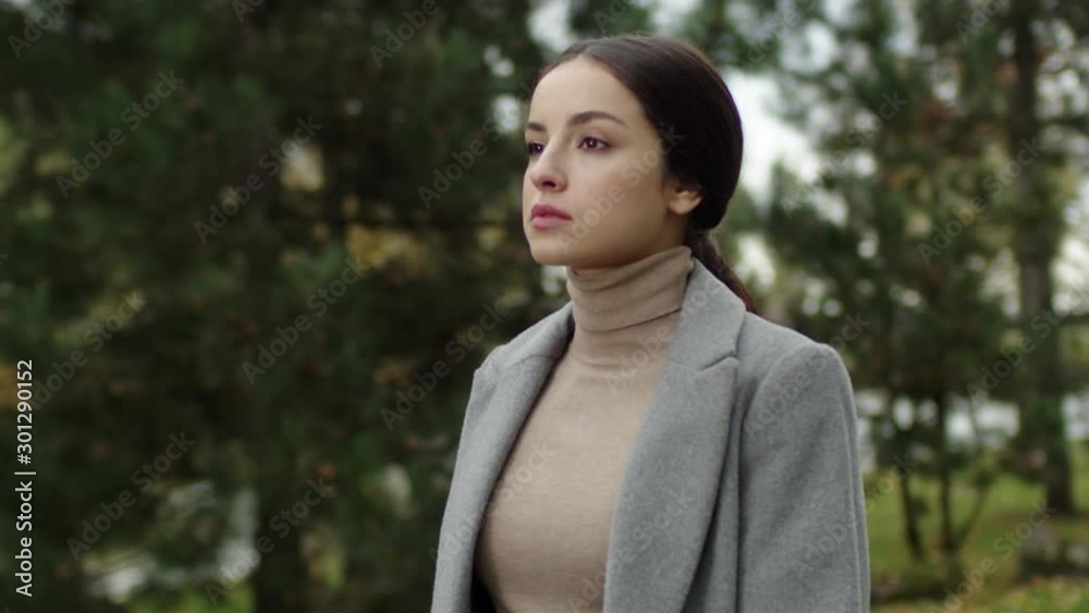 Young successful stylish businesswoman taking a walk in the city park. Wearing classical clothes. Girl looks around Young successful stylish businesswoman taking a walk in the city park. Wearing classical clothes. Girl looks around