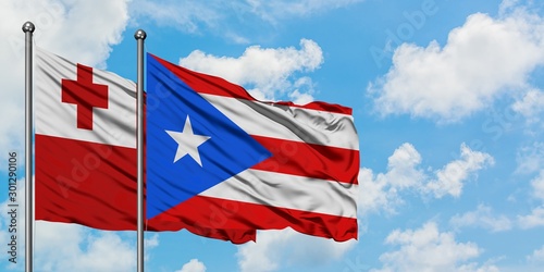 Tonga and Puerto Rico flag waving in the wind against white cloudy blue sky together. Diplomacy concept, international relations. photo