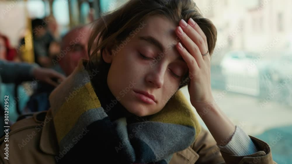 Sick young woman use phone headache feel bad on the tram cold autumn day flu season disease fever grippe health illness infection influenza migraine sickness slow motion Sick young woman use phone headache feel bad on the tram cold autumn day flu season disease fever grippe health illness infection influenza migraine sickness slow motion