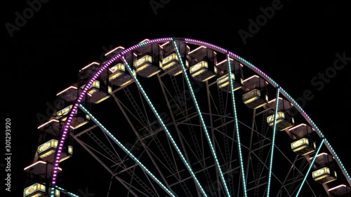 Spinning illuminated ferris wheel on fun fair at night,static close up photo