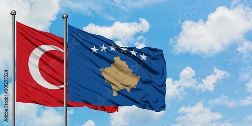 Turkey and Kosovo flag waving in the wind against white cloudy blue sky together. Diplomacy concept, international relations.