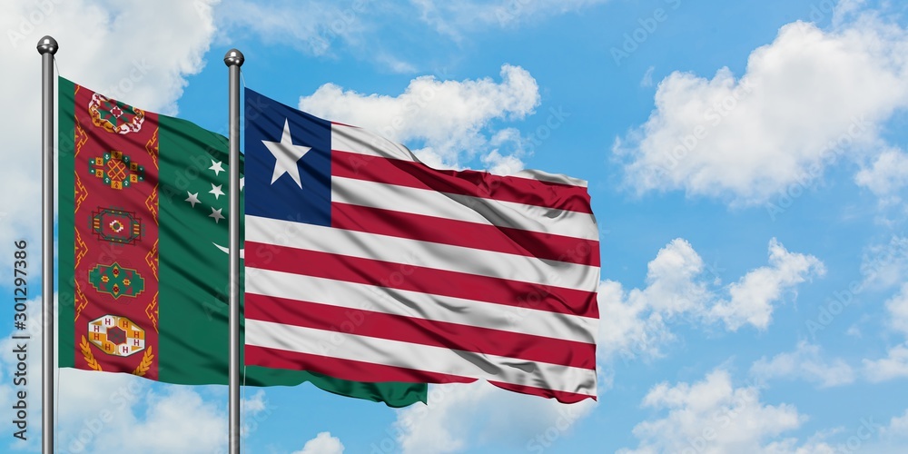 Turkmenistan and Liberia flag waving in the wind against white cloudy blue sky together. Diplomacy concept, international relations.