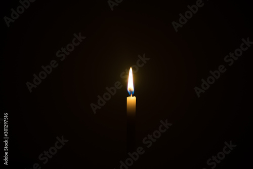 One candle light illuminated in a black background.