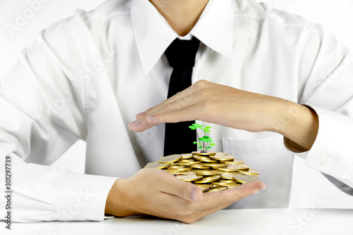 businessman hands protecting piles of golden coins,Lucky economic growth concept