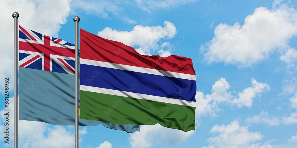 Tuvalu and Gambia flag waving in the wind against white cloudy blue sky together. Diplomacy concept, international relations.