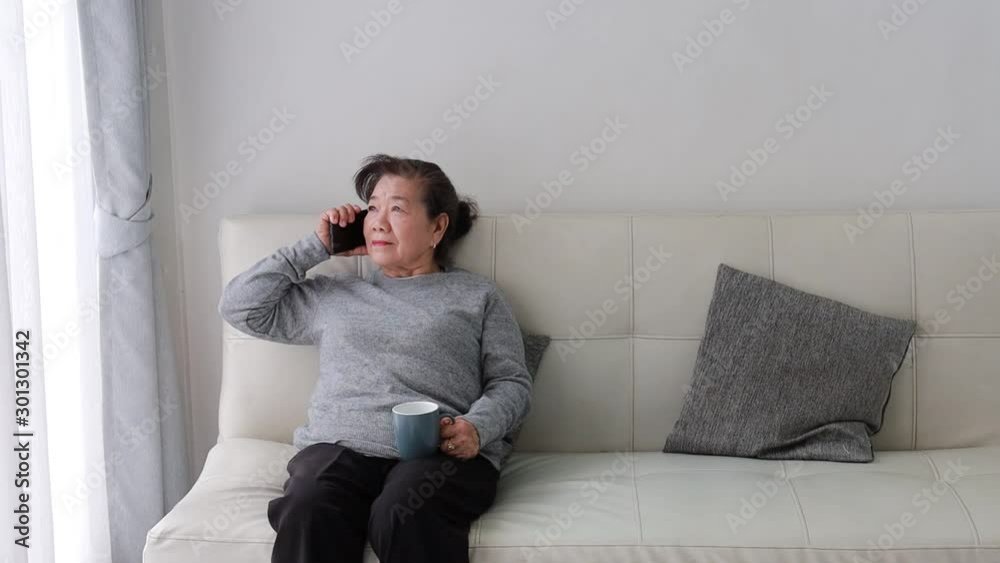 Asian senior woman in drinking coffee in living room Asian senior woman in drinking coffee in living room