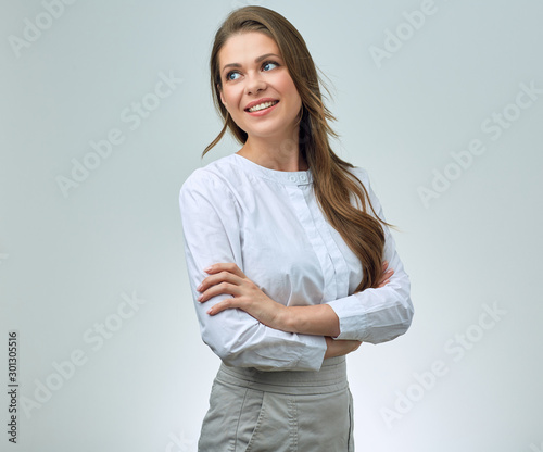 happy woman in white shirt and skirt, with long hair posing looking away to side.