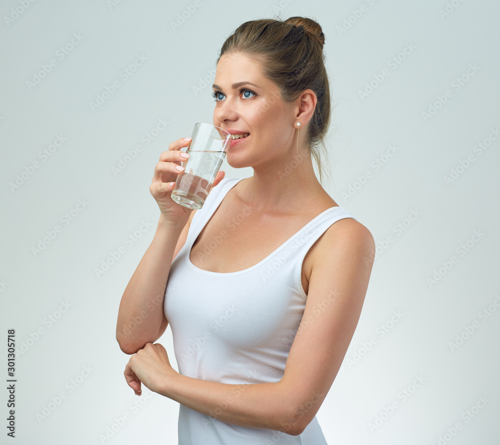 young woman in white sport vest drinking water from glass. young woman in white sport vest drinking water from glass.
