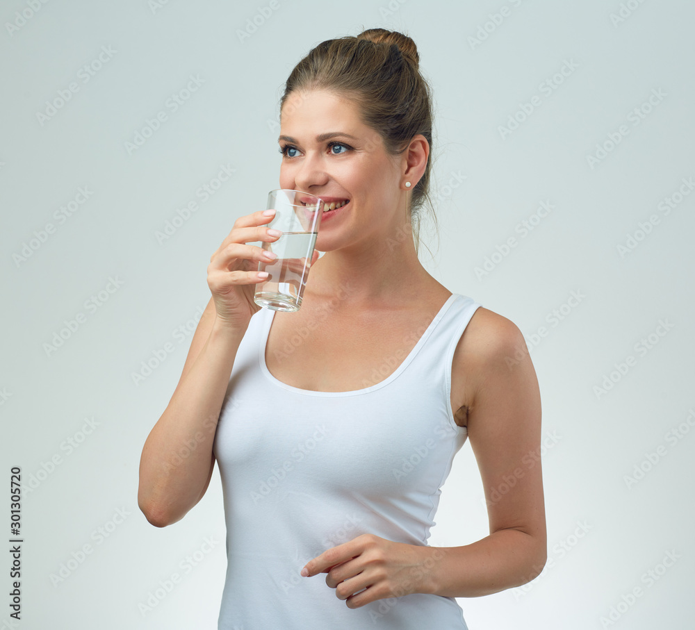 young woman in white sport vest drinking water from glass. young woman in white sport vest drinking water from glass.