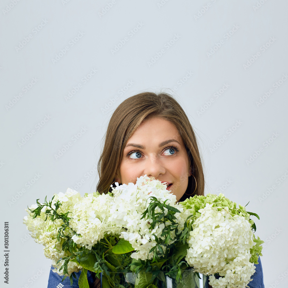 portrait of woman holding white flowers in front of face and looking away. portrait of woman holding white flowers in front of face and looking away.