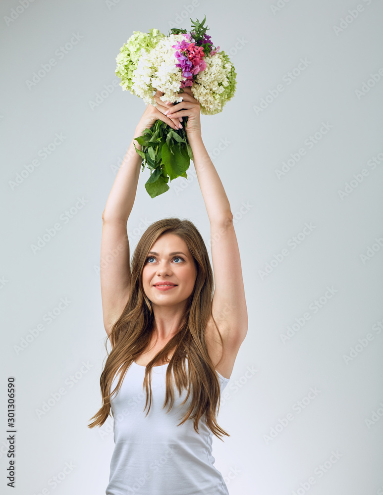 Happy bride girl in white dress holding flowers over head. Happy bride girl in white dress holding flowers over head.