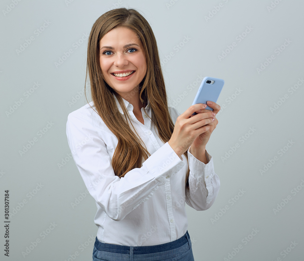 Smiling woman wearing white shirt using smartphone. Smiling woman wearing white shirt using smartphone.