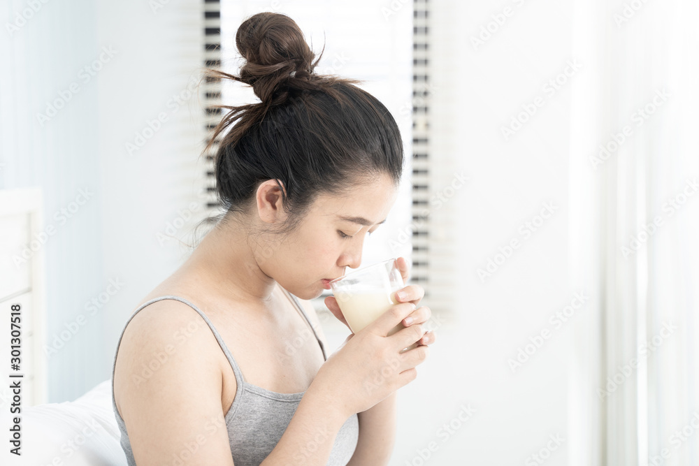Asian pregnant woman holding a glass of milk. Asian pregnant woman holding a glass of milk.