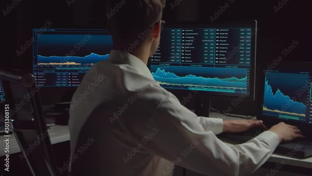 Trader working in office at night using workstation and analysis technology. Stock markets, crypto currency, global business, financial trading and banking. Trader working in office at night using workstation and analysis technology. Stock markets, crypto currency, global business, financial trading and banking.