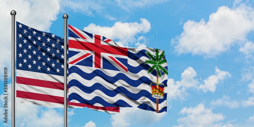 United States and British Indian Ocean Territory flag waving in the wind against white cloudy blue sky together. Diplomacy concept, international relations.