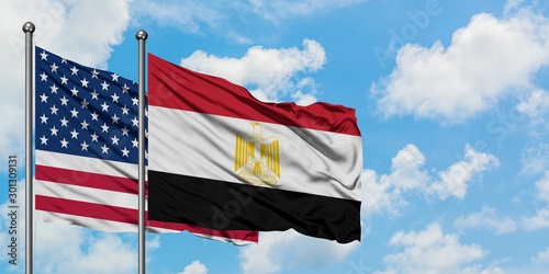Photography United States and Egypt flag waving in the wind against white cloudy blue sky together