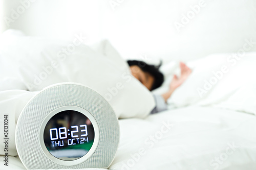 Alarm clock and little boy sleeping in the bedroom