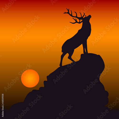 Silhouette of a deer on top of a mountain  head raised up  on a background of orange sunset