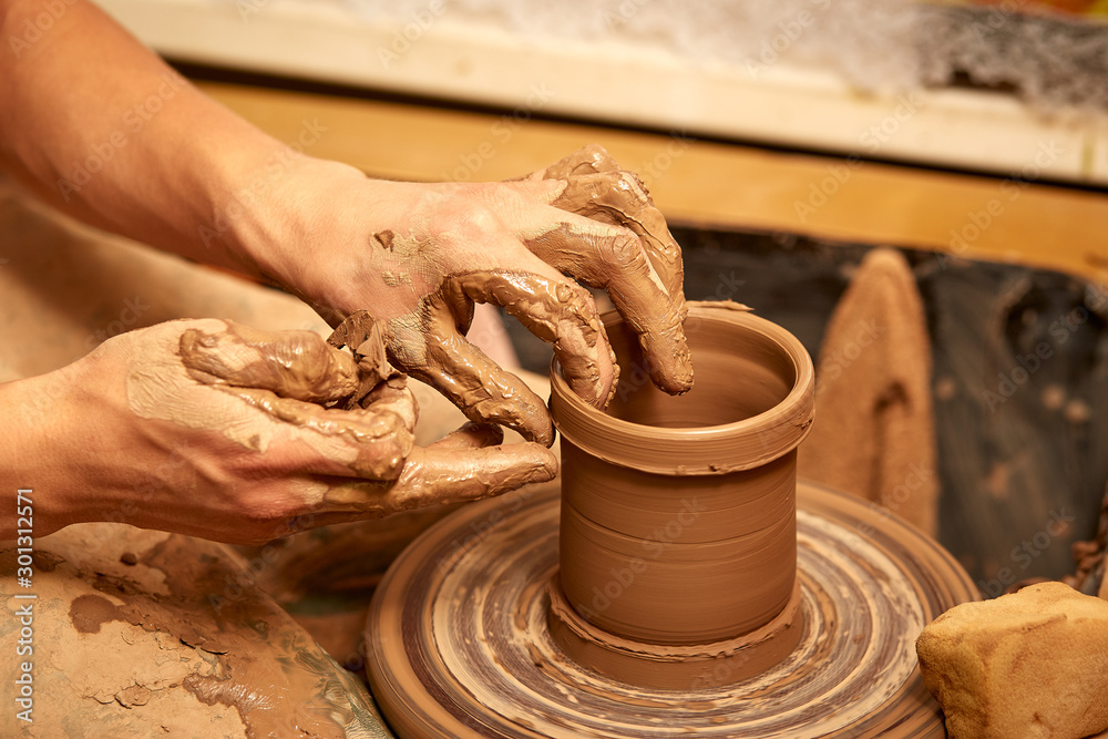 Man hands making clay jug macro. The sculptor in the workshop makes a jug out of earthenware closeup.