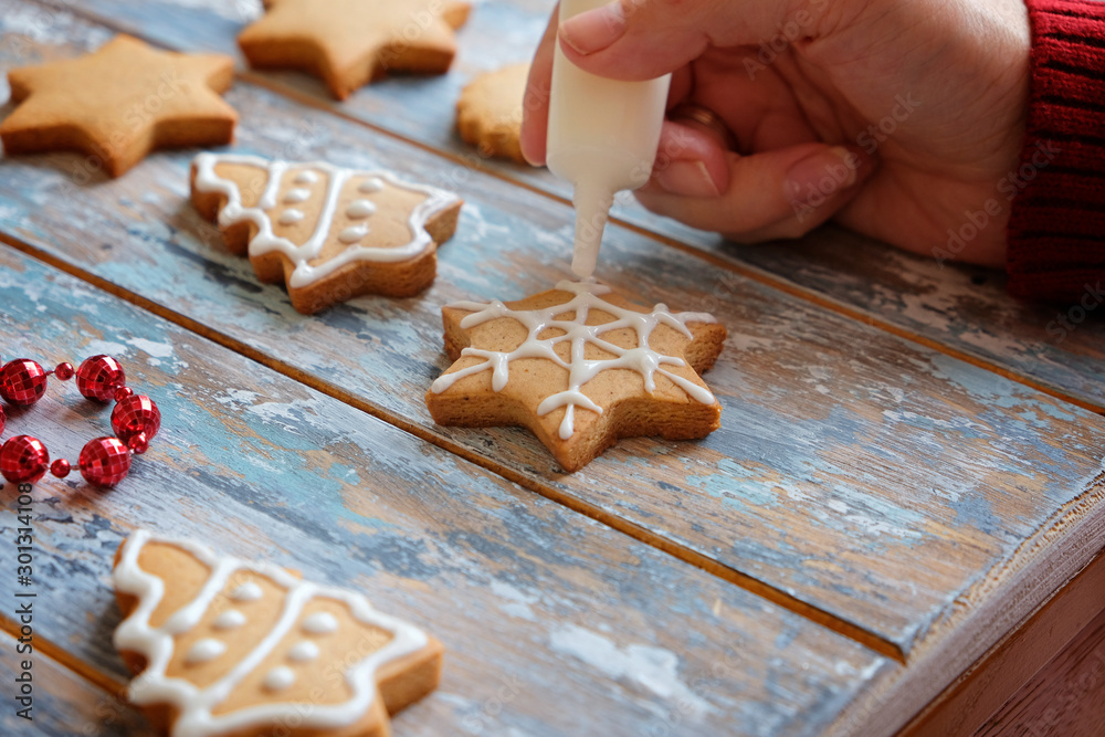 Making christmas ginger cookies with white glaze decoration, close up Making christmas ginger cookies with white glaze decoration, close up