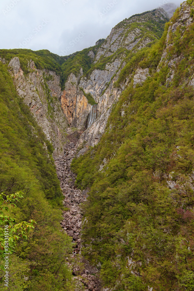 Beautiful landscape view of Boka Waterfall. It is the mightiest waterfall in Slovenia. It high is 106 altitude meters. It has the most width and flow speed in Slovenia.Concept of landscape and nature. Beautiful landscape view of Boka Waterfall. It is the mightiest waterfall in Slovenia. It high is 106 altitude meters. It has the most width and flow speed in Slovenia.Concept of landscape and nature.