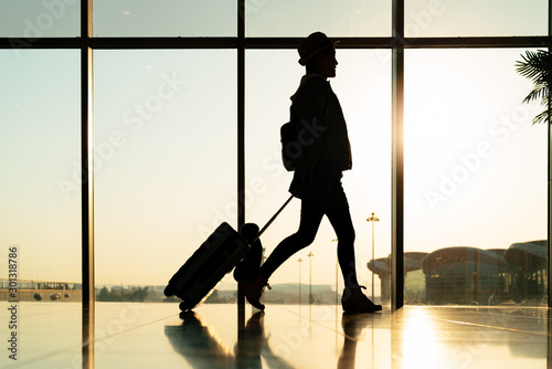 walking traveler with suitcase, passenger for tour in the airport terminal for air traveling