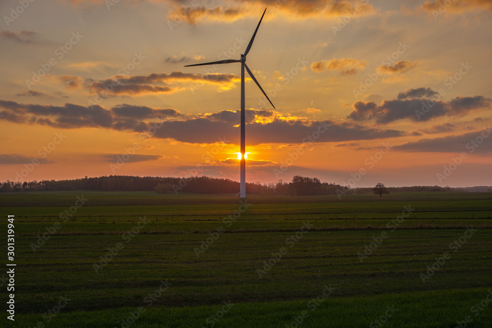 Obraz premium zachód słońca i turbina wiatrowa