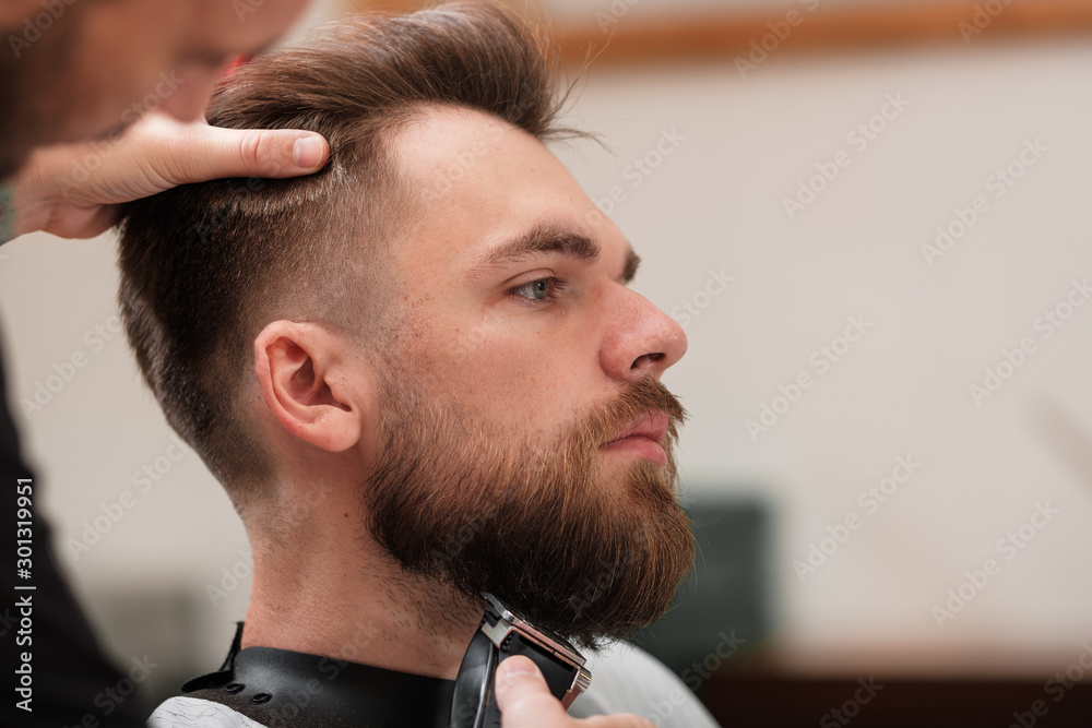 Obraz premium haircut beard typewriter. beard trimmer. Barber services. The man in the barbershop