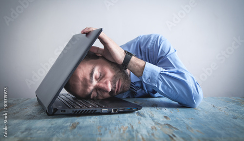 Businessman sleeping at desk in office.